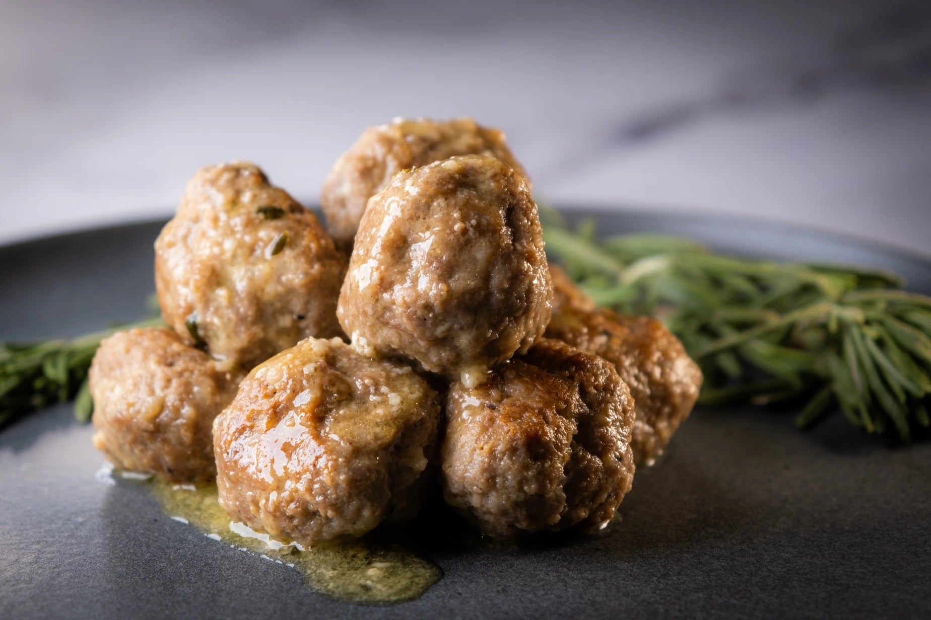 A plate of “polpette in bianco” Italian meatballs in white wine sauce.